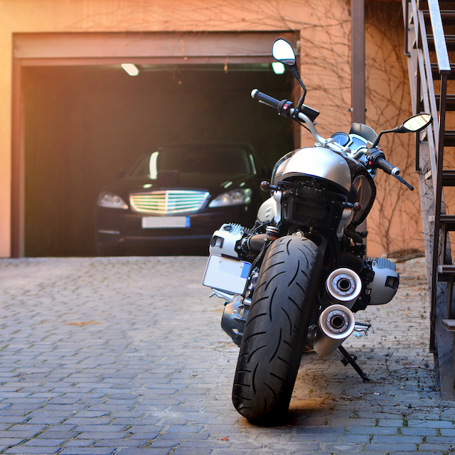 Motorbike and motorcyclist in a helmet on a city street.