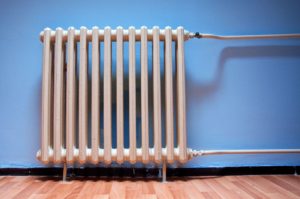 A heater in front of a blue background wall.